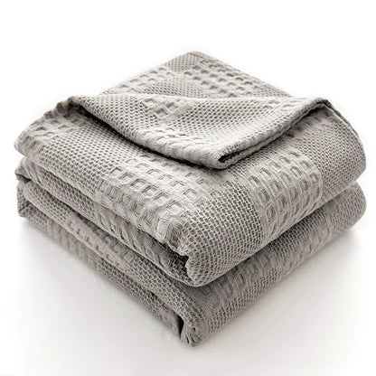 Cotton waffle throw blanket folded on a bed