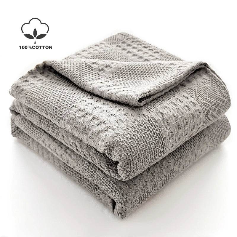 Cotton waffle throw blanket folded on a bed