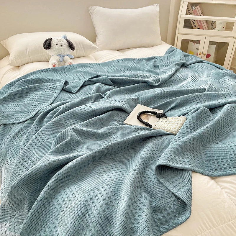 Cotton waffle throw blanket folded on a bed
