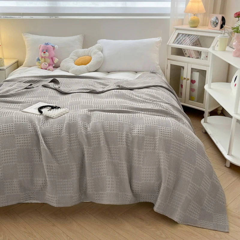 Cotton waffle throw blanket folded on a bed