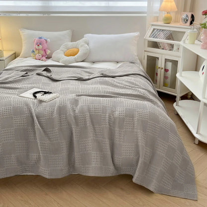Cotton waffle throw blanket folded on a bed