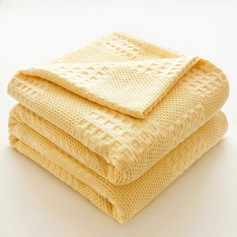 Cotton waffle throw blanket folded on a bed