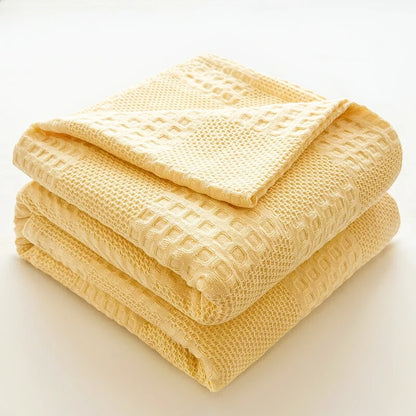 Cotton waffle throw blanket folded on a bed