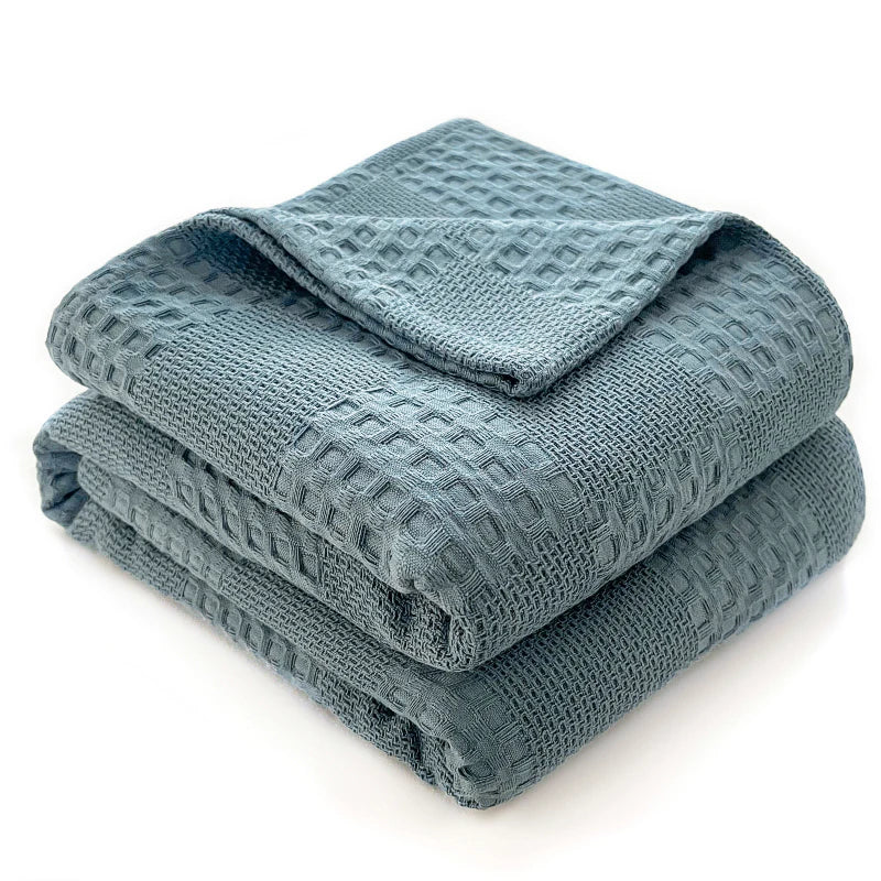 Cotton waffle throw blanket folded on a bed