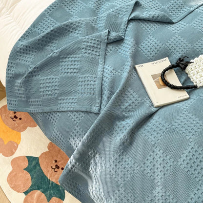 Cotton waffle throw blanket folded on a bed