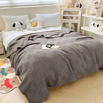 Cotton waffle throw blanket folded on a bed