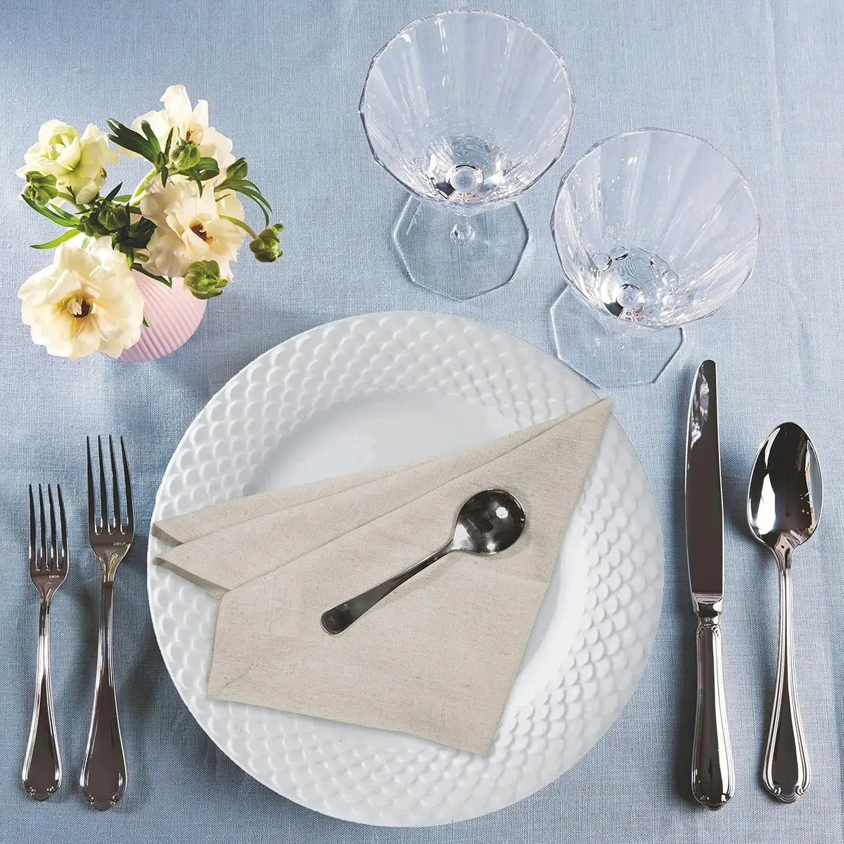 Set of six natural cloth dinner napkins on a table