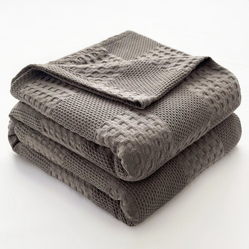 Cotton waffle throw blanket folded on a bed