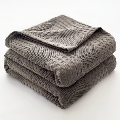 Cotton waffle throw blanket folded on a bed